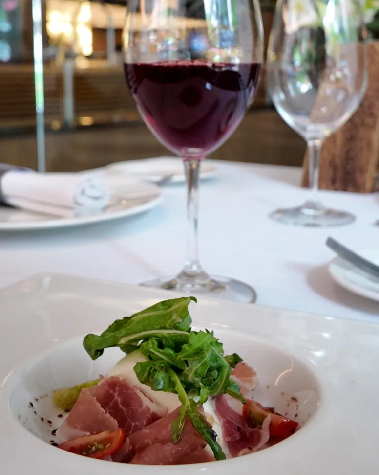 Ensalada de burrata con copa de vino tinto